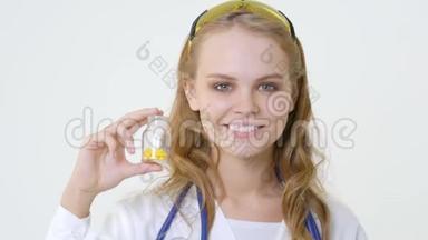 年轻的微笑医生带着一罐胶囊。 友好的女医生